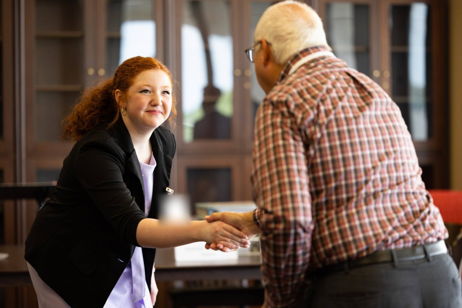 A student shaking hands with her judge after a round
