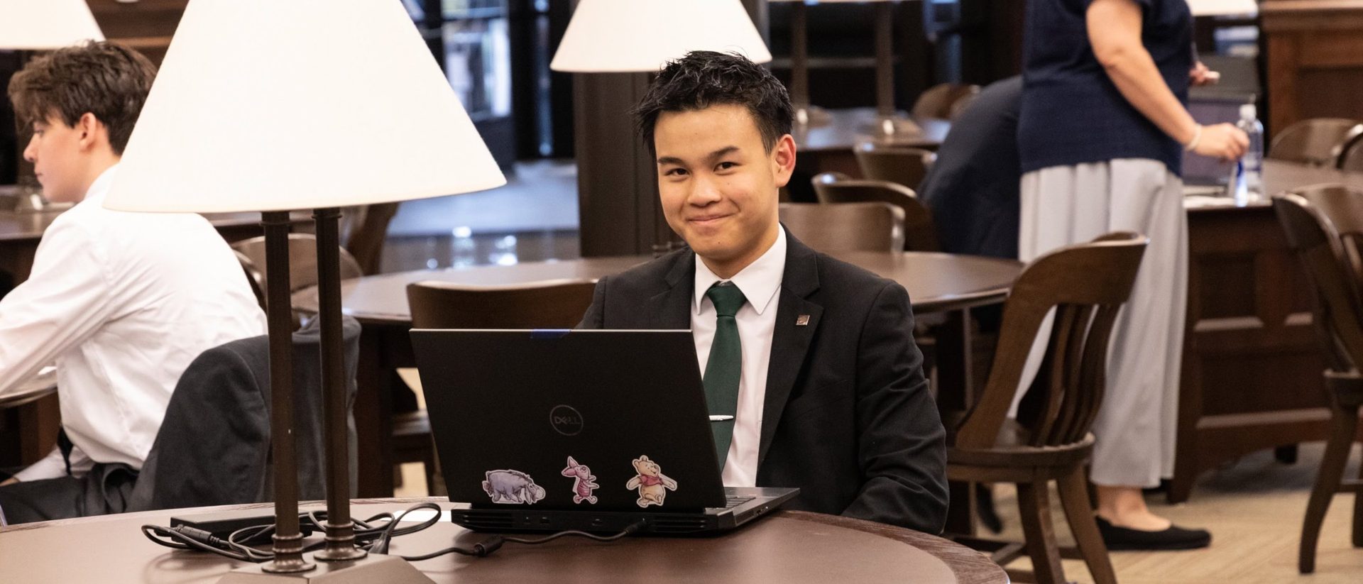 A student working on a laptop between rounds