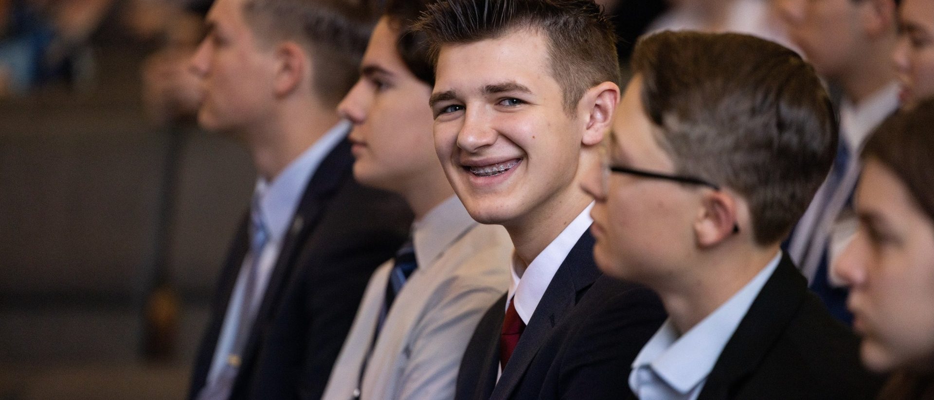Students smiling in a crowded auditorium